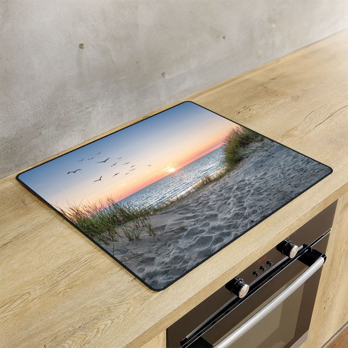 Inductie beschermer strand en duinen op de inductie plaat in de keuken