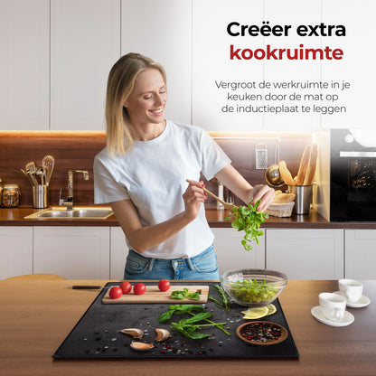 Vrouw in de keuken bezig met eten voorbereiden met behulp van de inductie beschermer kruiden en specerijen limoen